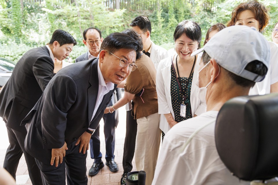 박강수 마포구청장이 휠체어를 탄 어르신의 안부를 살피고 있다.