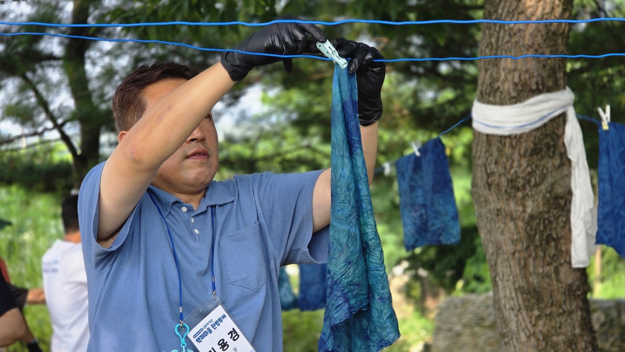 왕궁리 유적에서 천연 염색 체험(마치 공작소)으로 백제의 색을 직접 염색하며 오감으로 느끼고 있는 참가자