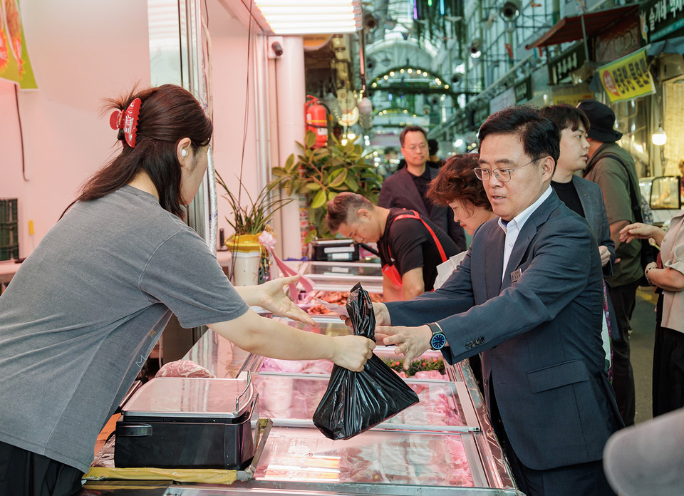 진교훈 강서구청장(오른쪽)이 방화동 방신전통시장을 찾아 온누리상품권으로 돼지고기를 구매하고 있다. 농축산물을 직접 구매하며 장바구니 체감 물가를 살폈다.
