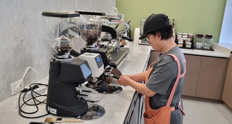 ‘마포 누구나 카페’에서 장애인 바리스타가 커피를 내리고 있다.