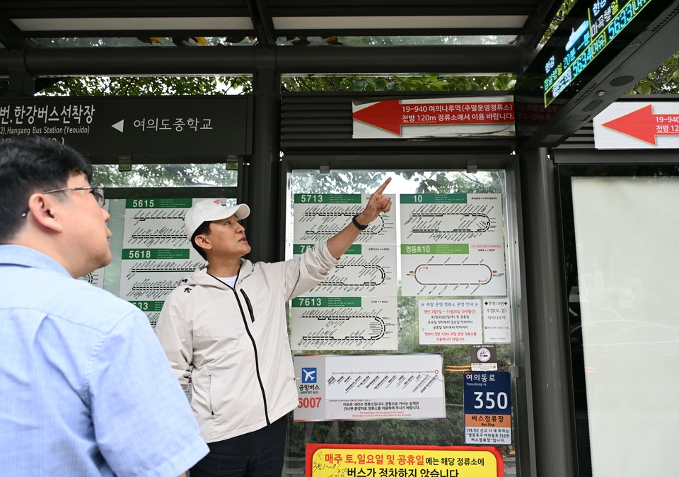 오세훈 서울시장이 18일(목) 오전, 한강버스 여의도선착장 인근 버스정류장을 찾아 한강버스 안내 시스템을 확인하고 있다.