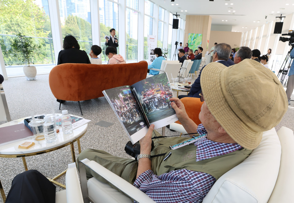양재천 수변문화쉼터에서 열린 사진전 주민 초대 행사에서 사진집을 보는 구민
