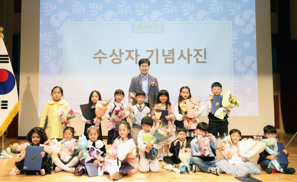 시상식에서 김진만 강남구 부구청장이 아이들과 기념사진을 찍고 있다