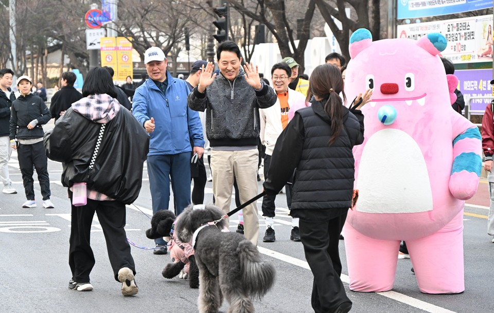 오세훈 서울시장이 22일(일) 오전 여의도공원에서 열린 '쉬엄쉬엄 모닝'에서 반려견과 함께 참여한 시민들의 완주를 응원하고 있다.